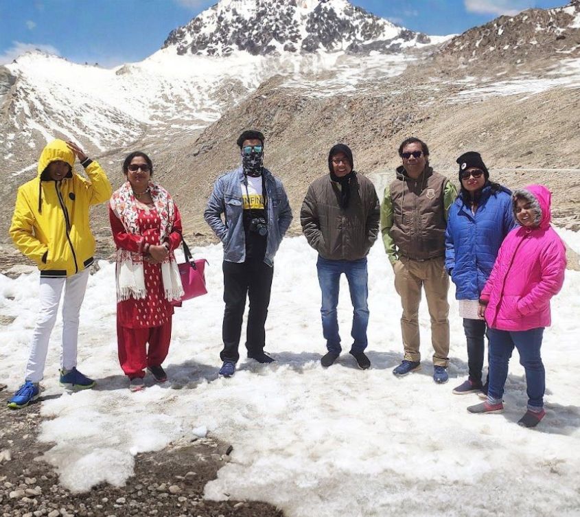 Group photo of happy travelers during Odyssey Travels’ Kashmir and Leh–Ladakh tour, enjoying scenic mountains and memorable moments.